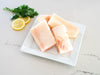 Wild Alaska Halibut Portions on White Plate with Lemons and Herbs